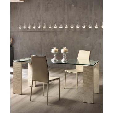 Millerighe fixed table with glass top and fossil stone structure. Available in two sizes and three different finishes